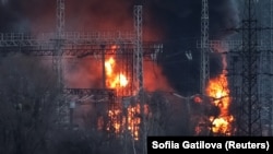 Дим і вогонь навколо високовольтних ліній на місці російського ракетного удару поблизу Харкова, 22 березня 2024 року