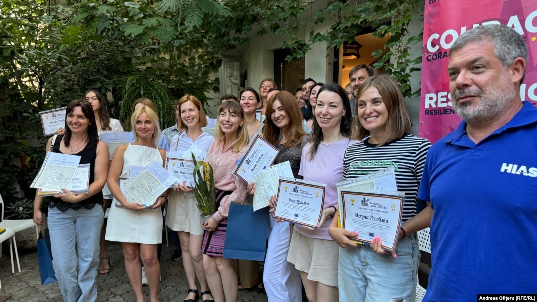 O parte dintre refugiații ucraineni care au urmat cursuri de limba română arată certificatele de competență în limba română.
