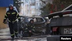 Пожежники гасять палаючі автомобілі після, за словами російської влади, удару українських військових у Б'лгороді, Росія, 30 грудня 2023 року
