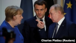 Президент Росії Володимир Путін жестикулює поруч з президентом Франції Еммануелем Макроном і тодішньою канцлеркою Німеччини Ангелою Меркель після саміту в Нормандському форматі в Парижі, Франція, 10 грудня 2019 року