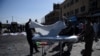 Afghan volunteers carry the bodies of victims at the scene of a suicide attack that targeted crowds of minority Shiite Hazaras during a demonstration at the in Kabul on July 23.