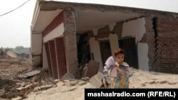 یوه ماشومه د سوځول شوي سکول په مخکې ولاړه ده