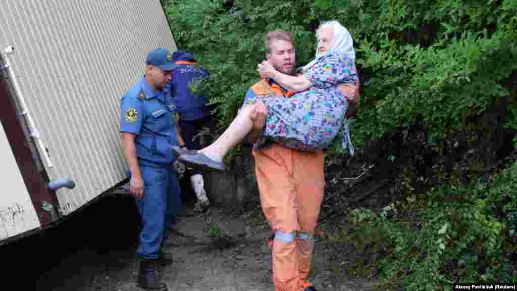 З усіх населених пунктів Бахчисарайського району селище Куйбишеве під час злив, що пройшли 4 липня в горах, постраждало найбільше. На фото: рятувальник несе на руках жінку похилого віку після затоплення