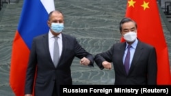 Russiýanyň daşary işler ministri Sergeý Lawrow (çepde) we Hytaýyň döwlet geňeşçisi we daşary işler ministri Wan Ýi Hytaýdaky duşuşykda, 22-nji mart, 2021