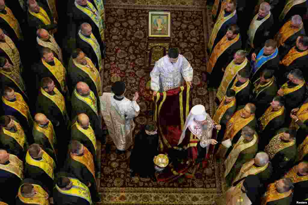 Metropolitan Epifaniy I, the head of the Orthodox Church of Ukraine, sprays holy water on military chaplains during a joint prayer for victory and for fair peace for Ukraine, in St. Michael's Cathedral in Kyiv.