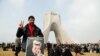 An Iranian man holds a poster with a cartoon of U.S. President Donald Trump during a ceremony to mark the 38th anniversary of the Islamic Revolution on Azadi Square in Tehran on February 10.