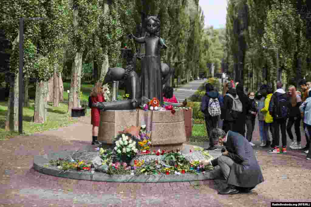 На фото: чоловік покладає квіти до пам'ятника дітям, розстріляним нацистами у Бабиному Яру