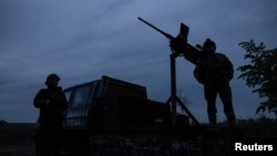 FILE PHOTO: Members of a mobile air defence volunteer unit stand next to their machine gun during the most massive Russian drone attack in Kyiv region