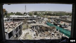 FILE: Workers remove debris from a damaged area a day after a suicide bomb attack near the foreign embassies in Kabul, Afghanistan on June 1.