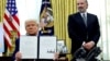 US President Donald Trump holds an executive order about tariffs increase while flanked by Commerce Secretary Howard Lutnick in Washington.