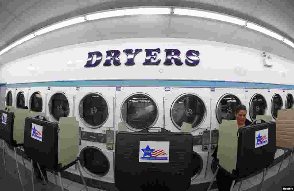 A voter casts her ballot inside a laundromat in Chicago, Illinois. 