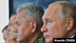 Президент России Владимир Путин и министр обороны РФ Сергей Шойгу (справа налево) наблюдают за ходом основного этапа стратегических командно-штабных учений «Кавказ-2020» на полигоне Капустин Яр. 25 сентября 2020 года
