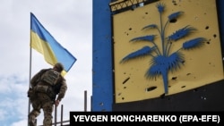 Український військовий встановлює прапор України на адмінмежі між Харківською і Донецькою областями після звільнення ЗСУ цієї території від військ РФ, 20 вересня 2022 року