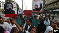 Pakistani human rights activists hold images of missing activist Salman Haider during a protest in Karachi on January 9.