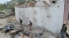 Security personnel inspect a damaged police post following an airstrike in Bati Kot district in Nangarhar province, August 1, 2013