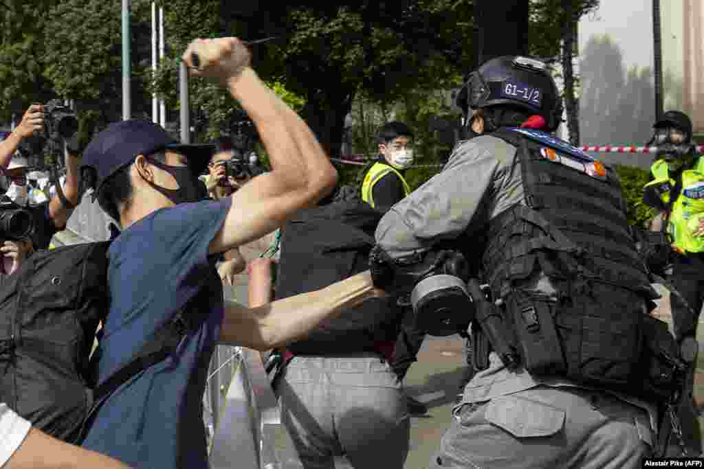 На фото з протестів у Гонконгу 1 липня протестувальник намагається вдарити гострим предметом поліцейського, який намагається його затримати