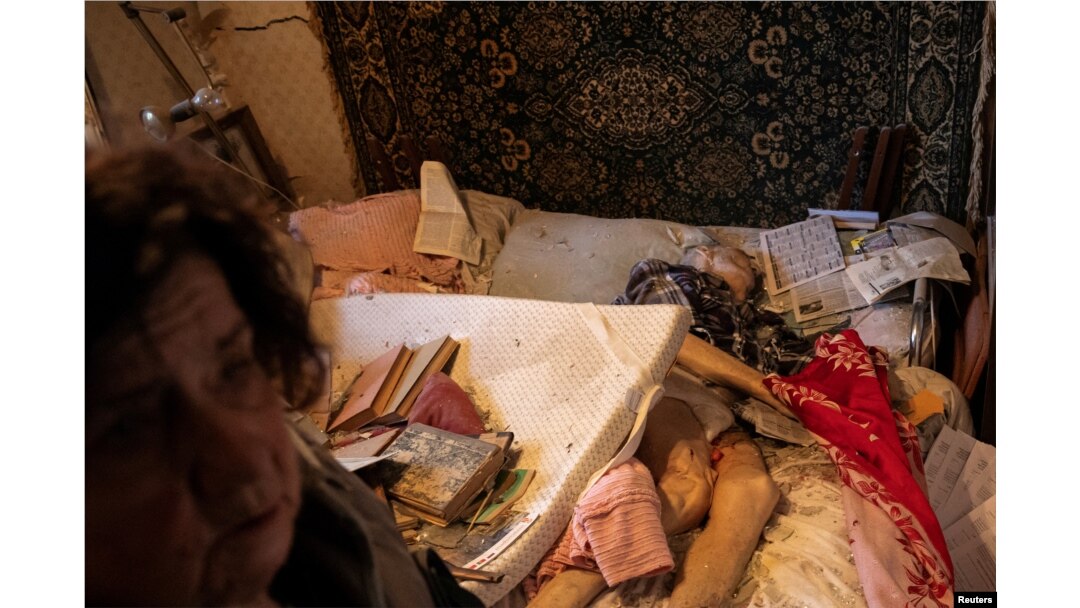 Inna Khristici stă în dormitorul ei lângă cadavrul soțului ei, Olexandr Khristici, un bărbat în vârstă de 79 de ani care a fost ucis într-un atac cu rachete rusești asupra blocurilor de locuințe din Harkov. Putin continuă să susțină că nu atacă decât ținte militare.