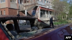 Un bărbat trece pe lângă o clădire avariată în urma unui atac cu drone rusești în Odesa, pe 22 aprilie 2025.