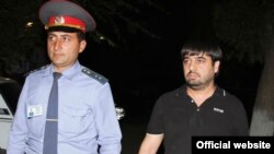 Ոստիկանը ուղեկցում է ձերբակալված Սեւակ Մինասյանին: Լուսանկարը` Գագիկ Շամշյանի