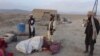 Afghan men gather at the site of an airstrike in Dasht-e-Bari village in Logar province near Kabul on August 30.